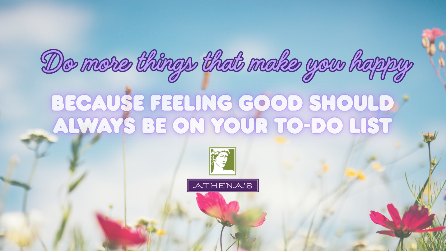 A motivational quote graphic reading 'Do more things that make you happy BECAUSE FEELING GOOD SHOULD ALWAYS BE ON YOUR TO-DO LIST' over a blurred meadow with pink flowers and a blue sky. The Athena's logo appears near the bottom center.
